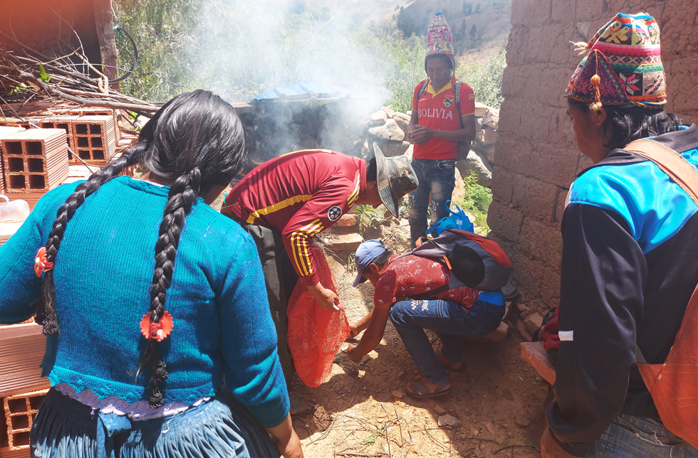 Bolivien: Eine Gruppe Menschen schaut interessiert dem Leiter zu, der etwas demonstriert.