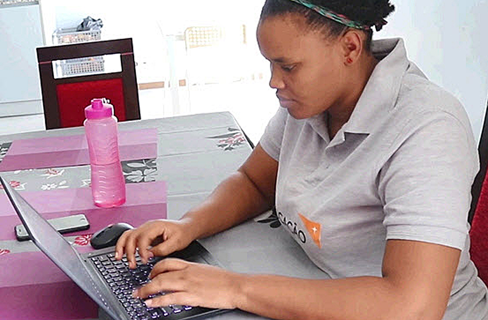 Eine World Vision-Mitarbeiterin in Mosambik arbeitet an ihrem Laptop.