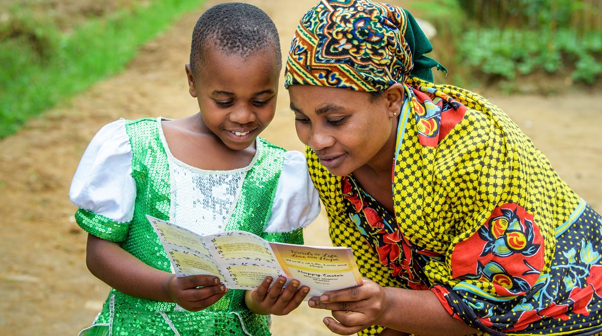 Une fillette du Rwanda et sa mère lisent ensemble une lettre de leur marraine World Vision.
