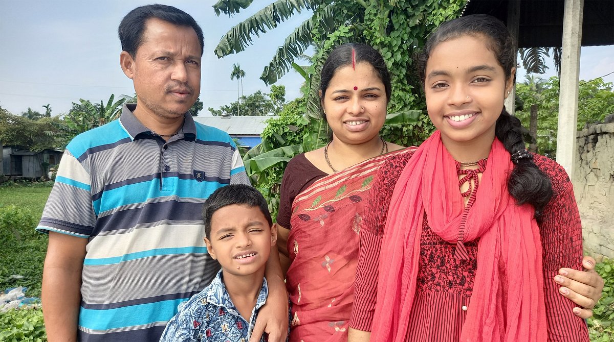 Bangladesch: Eine Familie posiert für das Foto. Rechts im Bild ist Prety, sie ist Mitglied im World Vision-Kinderclub.