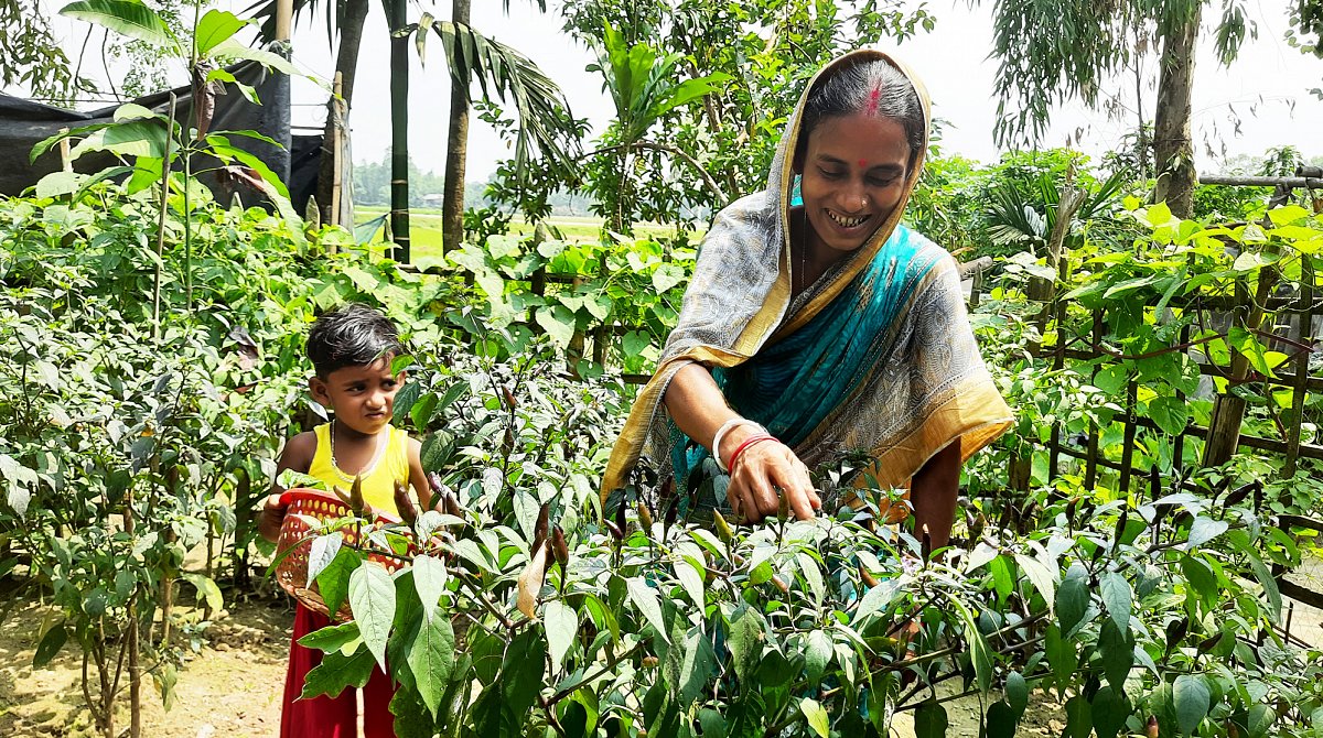 Bangladesch: Mutter mit Sohn in einem Gemüsegarten.