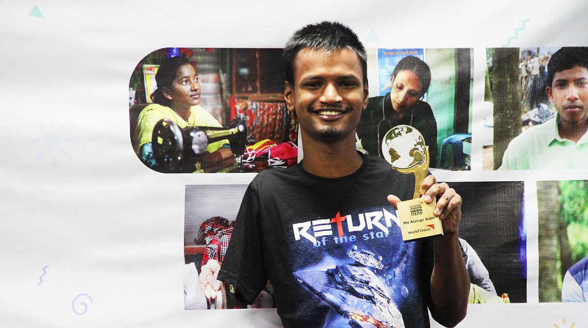 Bangladesch: Ein junger Mann zeigt seine Auszeichnung als Hidden Hero von World Vision.