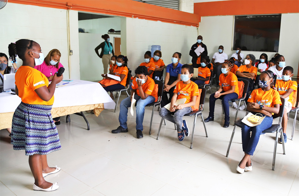 Dominikanische Republik: Ein Mädchens steht mit einem Mikrofon vor der Klasse.