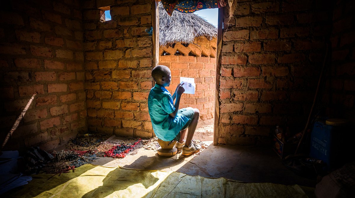 Sambia: Ein Junge liest einen Brief
