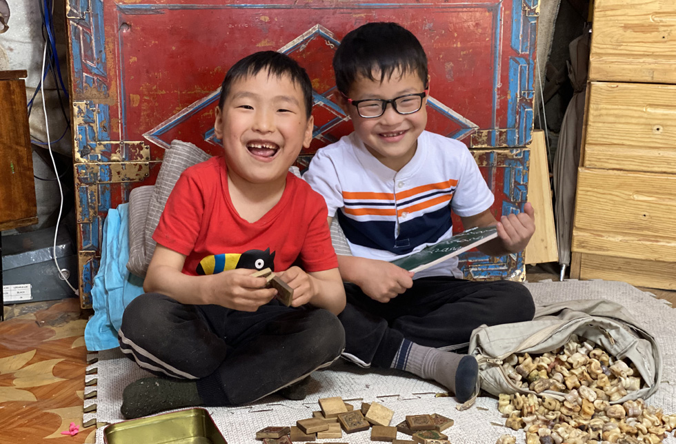 Mongolei: Zwei Jungen im World Vision-Entwicklungsprojekt Bayangol sitzen am Boden und spielen miteinander.