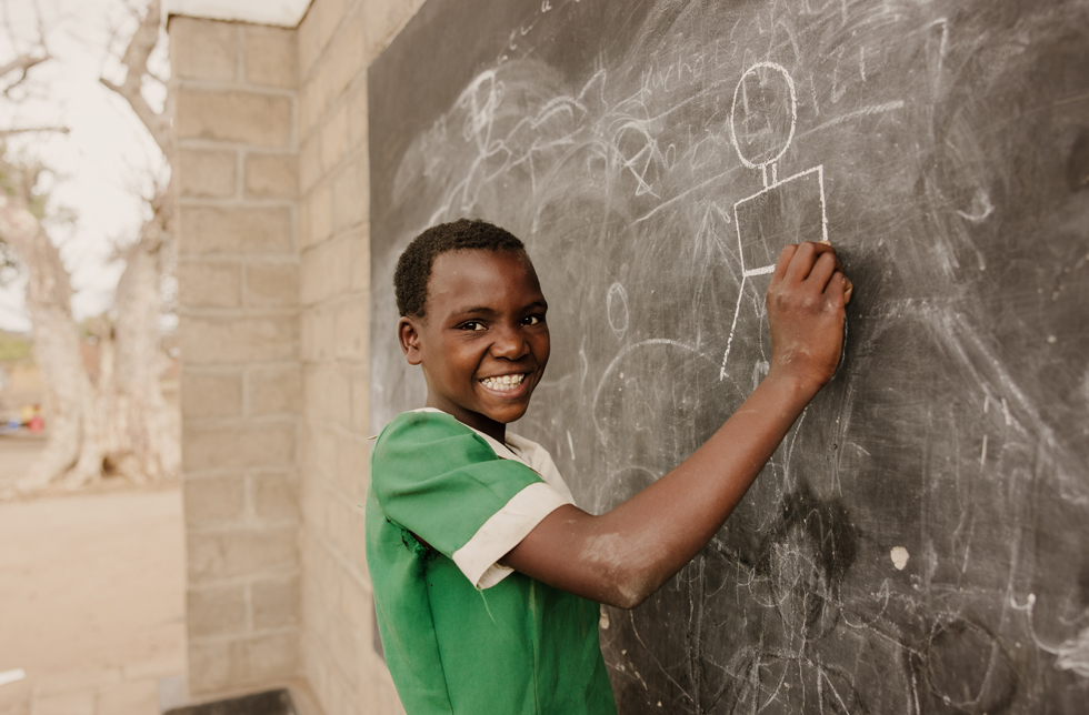 Malawi: Ein Junge zeichnet an der Schultafel.