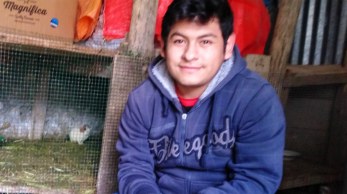 Peru: Ein junger Mann kauert vor einem Meerschweinchenstall