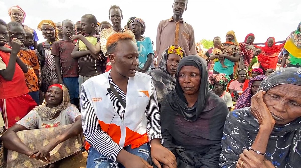 Südsudan: Eine World Vision-Mitarbeiterin spricht mit einer geflüchteten Frau. Um sie herum stehen weitere Flüchtlinge.
