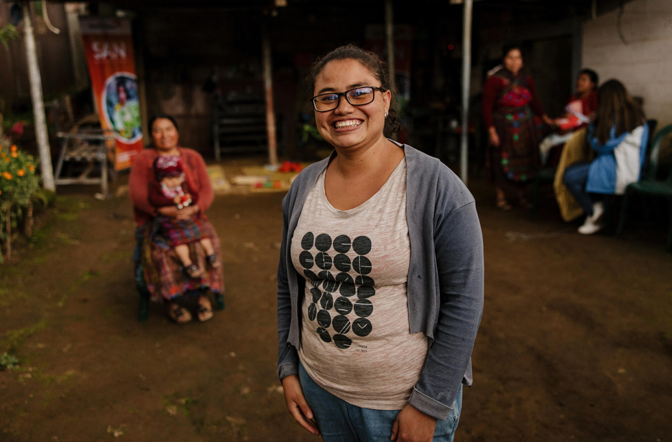 Guatemala: Eine junge Frau mit Brille lacht in die Kamera.