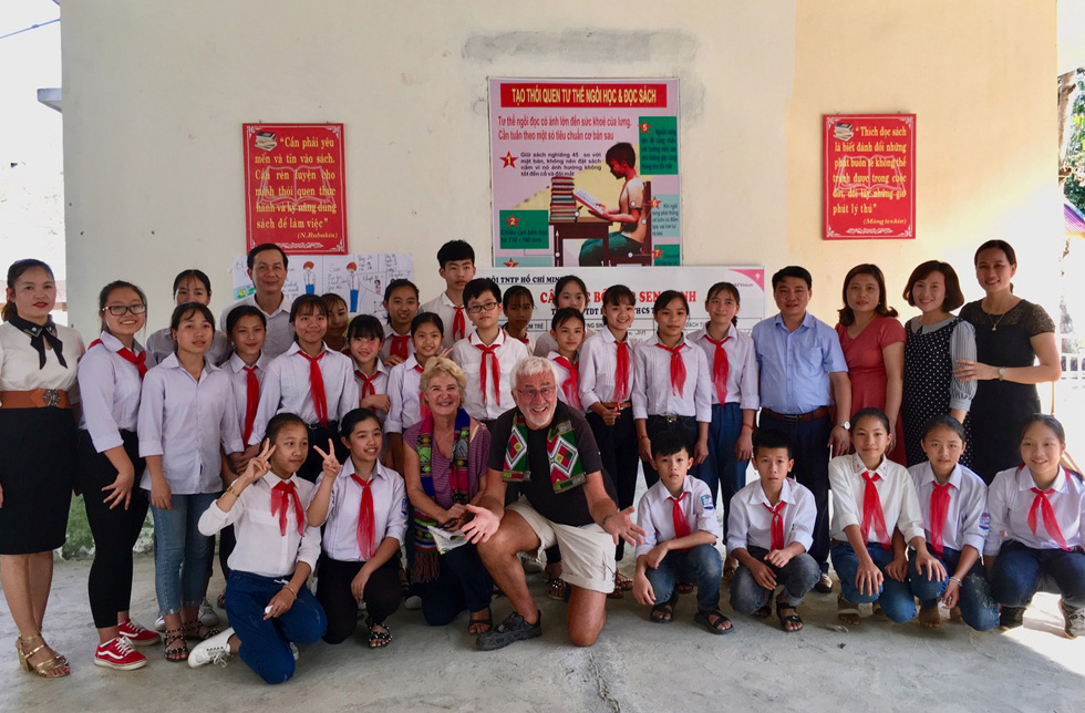 Vietnam: Eine Schulklasse in Schuluniformen mit roten Halstüchern mit europäischen Besuchern.