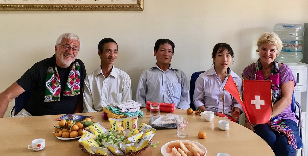 Vietnam: Eine Gruppe von Frauen und Männern, zwei Schweizer und drei Vietnamesen, sitzen um einen Tisch herum