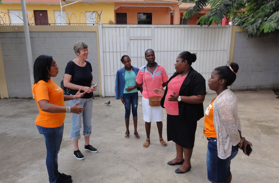 Dominikanische Republik: Im Innenhof des World Vision-Büros begrüsst eine Mutter mit ihrer Tochter World-Vision-Mitarbeiterinnen und eine Patin aus der Schweiz.