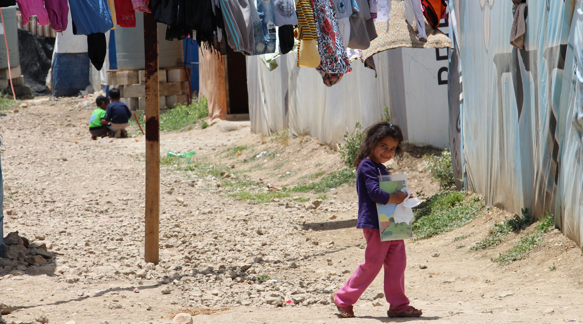In einer Flüchtlingssiedlung macht sich ein Mädchen auf den Weg zum Schulunterricht