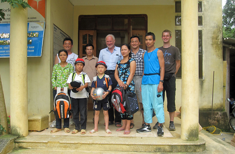 Vietnam: Kurt Jenni mit seinem Enkel, zwei Patenkindern, Lehrern und World Vision-Mitarbeitenden vor der Schule.