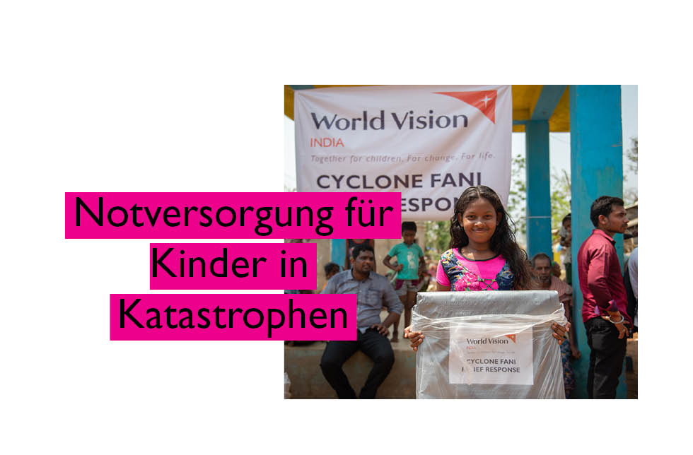 Indien: Notversorgung für Kinder in Katastrophen. Ein Mädchen steht vor einem World Vision-Plakat. In ihren Händen hält sie ein Nothilfepaket.