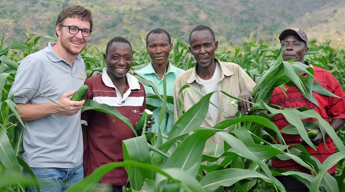 World Vision Schweiz Mitarbeiter mit Kleinbauern im Maisfeld