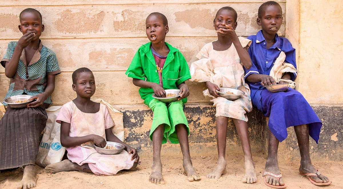 Kinder im Südsudan essen glücklich ihre Mahlzeit