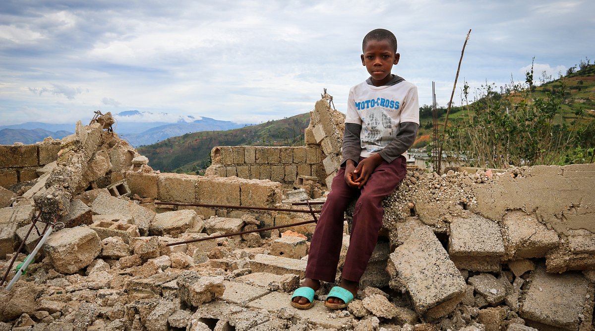 Knabe in Haiti in seinem zerstörten Haus nach Hurrikan Matthew