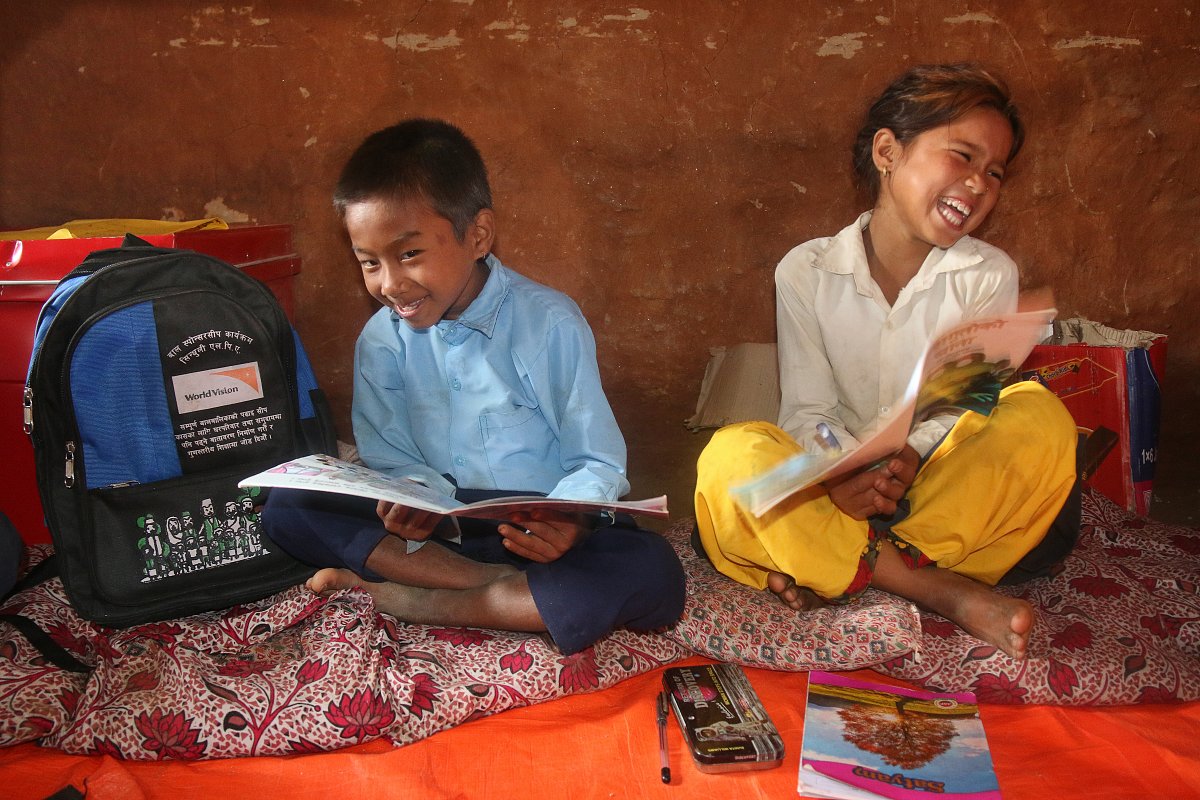 Ein Junge und ein Mädchen in Nepal freuen sich über Bücher