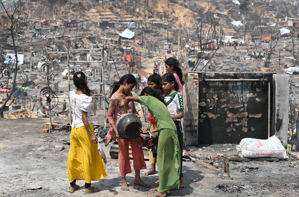 Mädchen in einer abgebrandten Siedlung finden einen Topf in der Asche