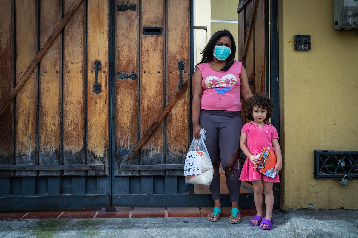 Eine Frau und ihre Tochter stehen vor ihrem Haus in Ecuador.