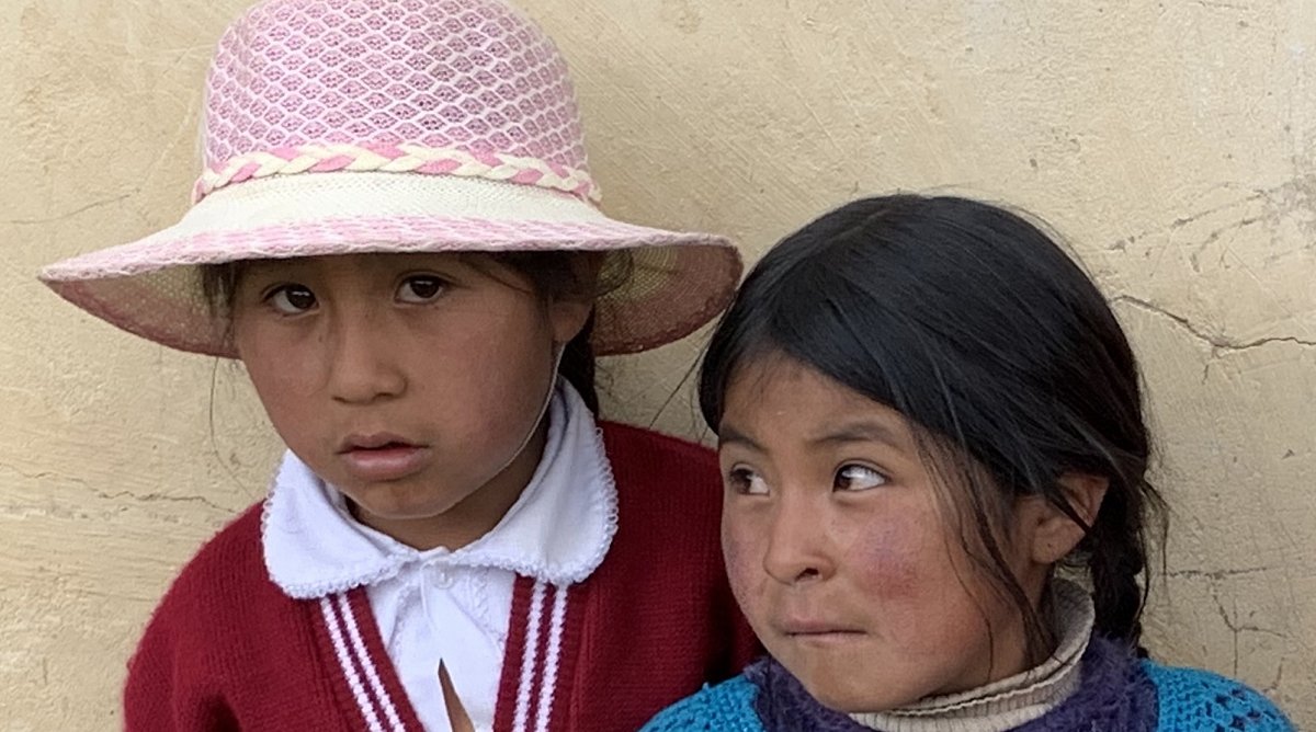 Zwei Mädchen vor einem Haus in Bolivien.