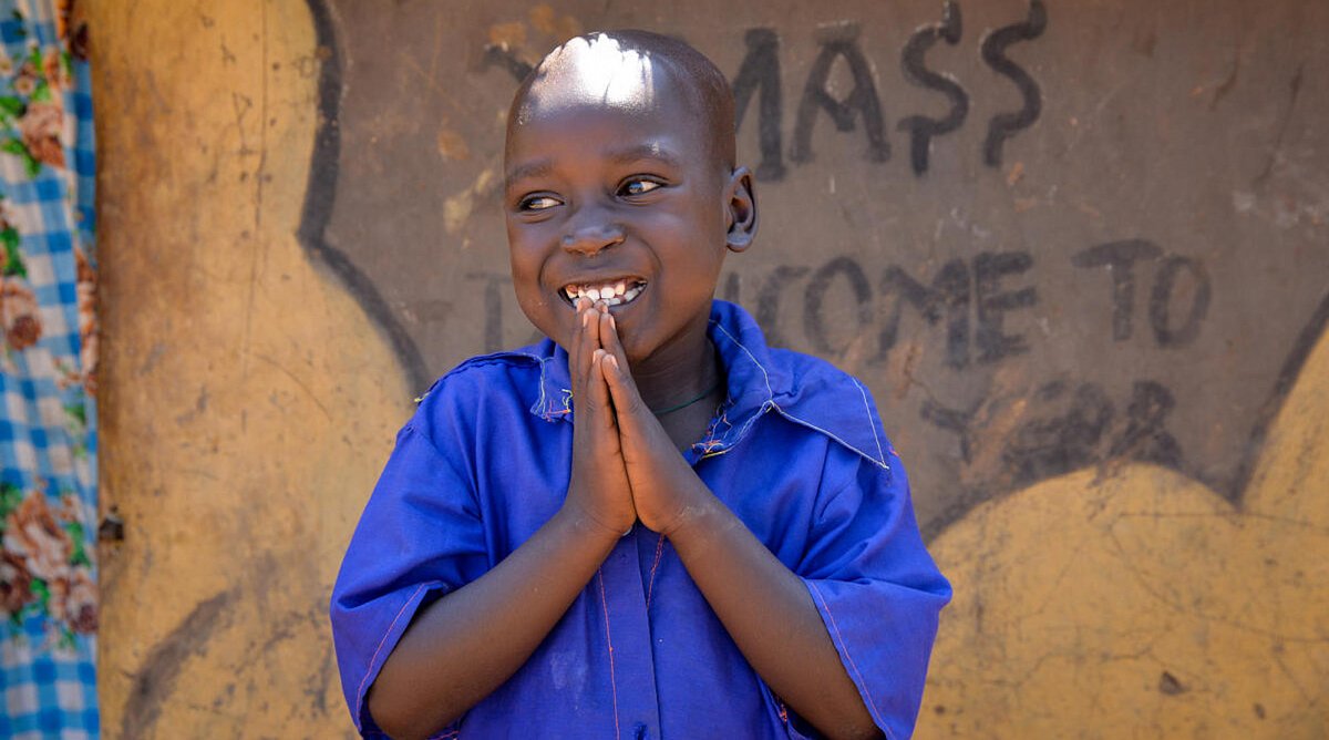 Ein Junge vor einem Haus in Uganda
