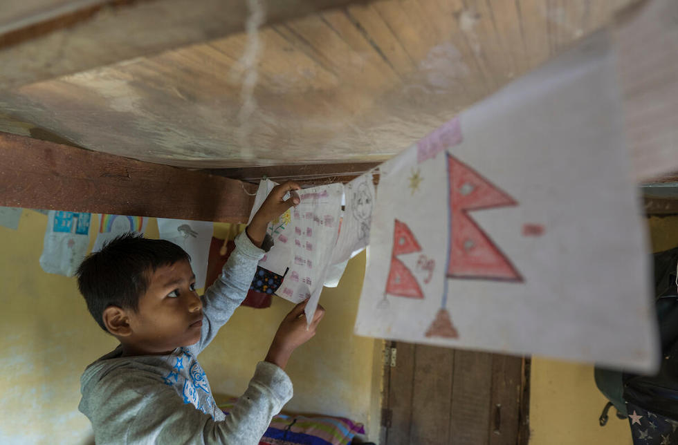 Ein Junge mit selbstgemalten Bildern in Nepal