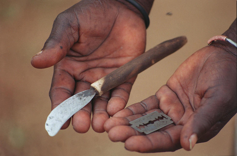 Kenia: Zwei Hände, in denen ein altes Messer und eine Rasierklinge liegen. 