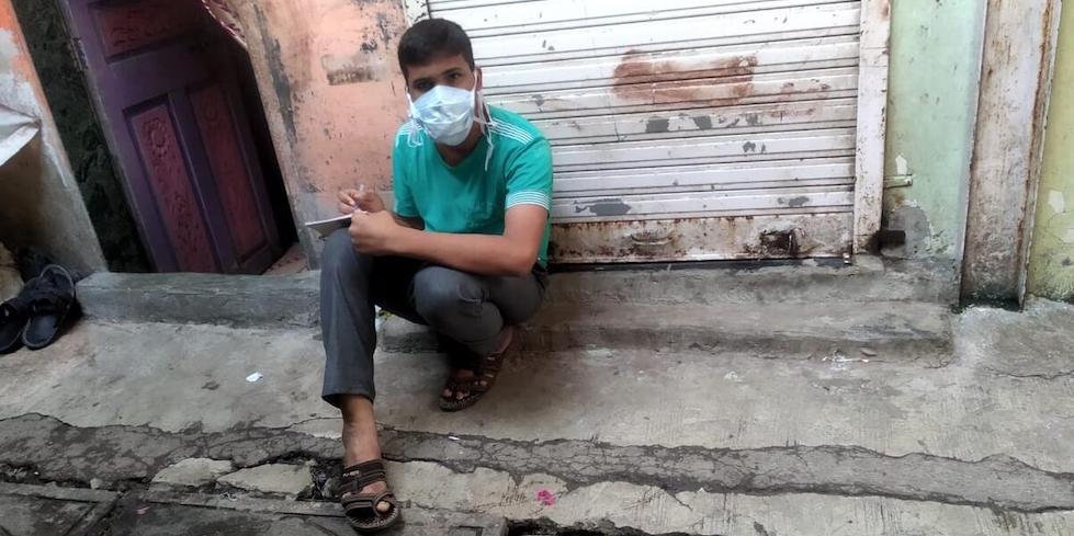 Indien: Der 14-jährige Sufian sitzt vor seinem Haus und macht Notizen.