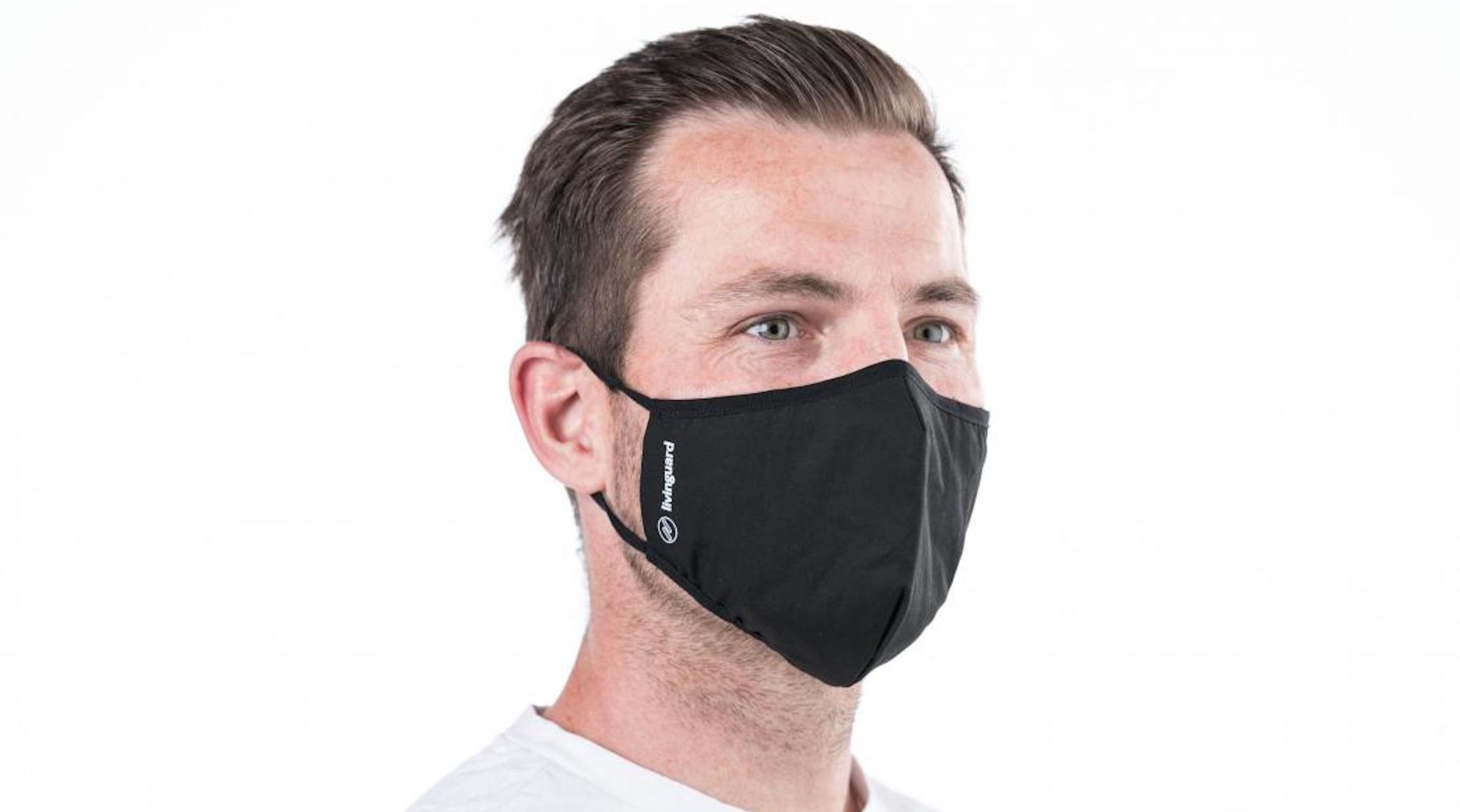 Ein Mann trägt einen Mund-Nasen-Schutz aus schwarzem Stoff.