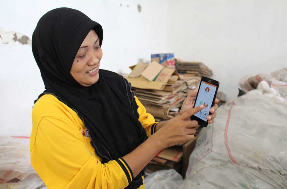 Indonesien: Eine Person hat auf dem Smartphone die Waste Bank-App installiert.