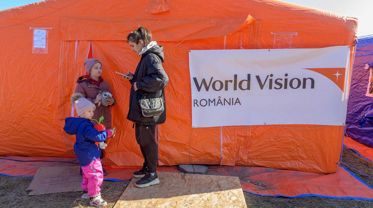 Ukraine/Rumänien: Eine Mutter wartet mit ihren beiden Töchtern vor einer Kinderschutzzone von World Vision.