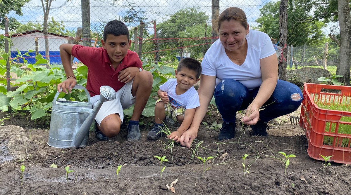 Nicaragua: Zwei Kinder und ihre Mutter beim Pflanzen von Gemüsesetzlingen im Garten.