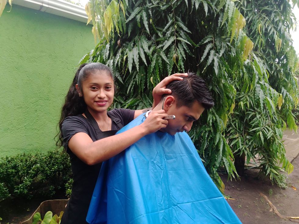 Nicaragua: Eine junge Frau schneidet einem Mann die Haare.