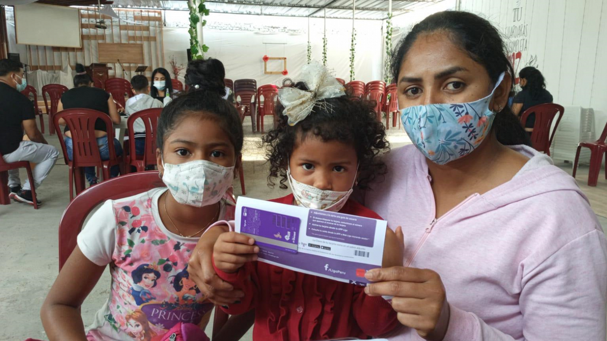 Peru: Mutter und zwei Kinder mit einem Gutschein für Bargeld.