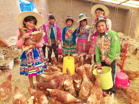 Eine Familie im Entwicklungsprojekt Sumaj-Muju befindet sich im neu gebauten Hühnerstall.