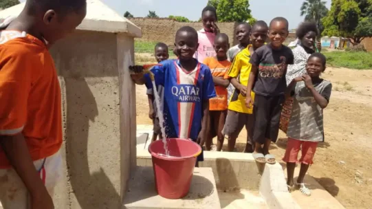 Kinder im Entwicklungsprojekt Diago in Mali probieren den neuen Wasserhahn aus.