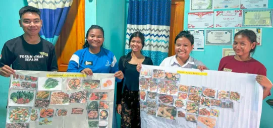 Des jeunes brandissent des pancartes avec leurs revendications en matière de nutrition.