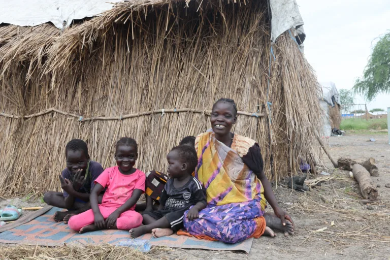 Mary et ses enfants sont assis devant leur logement de fortune à Tonga Payam, au Soudan du Sud