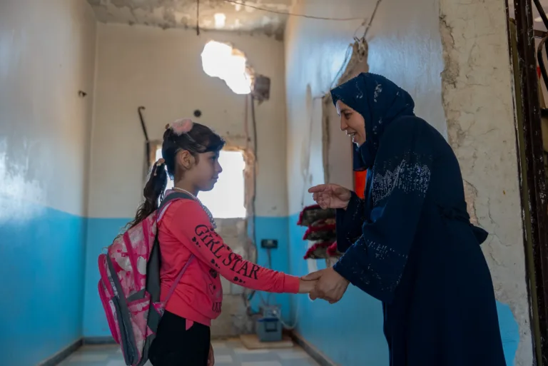 Amal und ihre Mutter Samia stehen in einem durch Einschläge beschädigtem Gebäude im ländlichen Syrien.