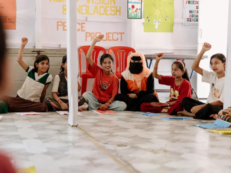 Au Bangladesh, Win est assis World Vision terre dans un groupe d'étude organisé par World Vision et lève la main.